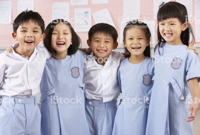 Portait Of Students In Chinese School Classroom Laughing At Camera