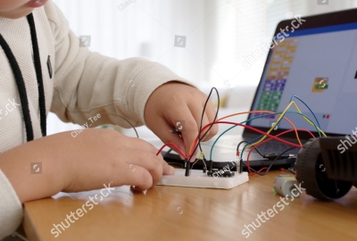 stock-photo-young-asia-student-remotely-learn-online-at-home-in-coding-robot-car-and-electronic-board-cable-in-1978128827